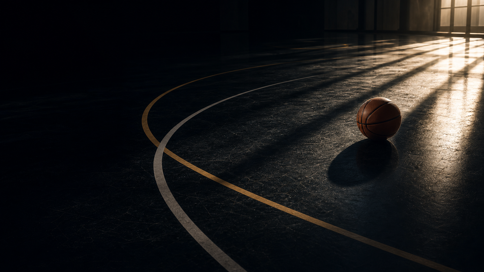 Dramatic indoor basketball court with a ball in window light